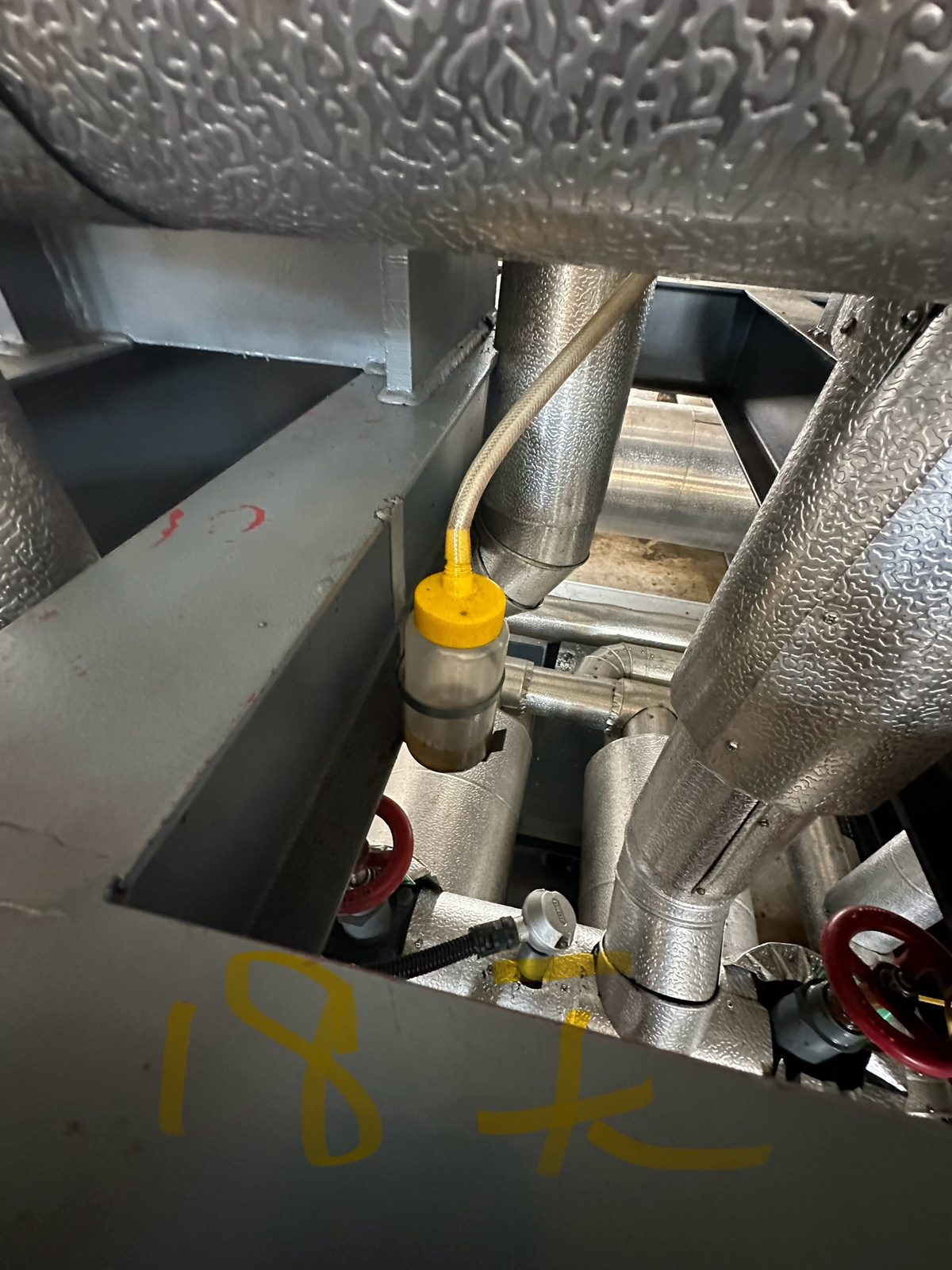 Shaft-seal leak collection bottle on the package frame